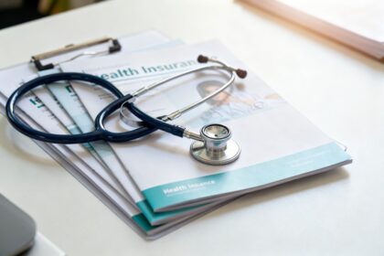 Stéthoscope posé sur des brochures de complémentaire santé sur un bureau